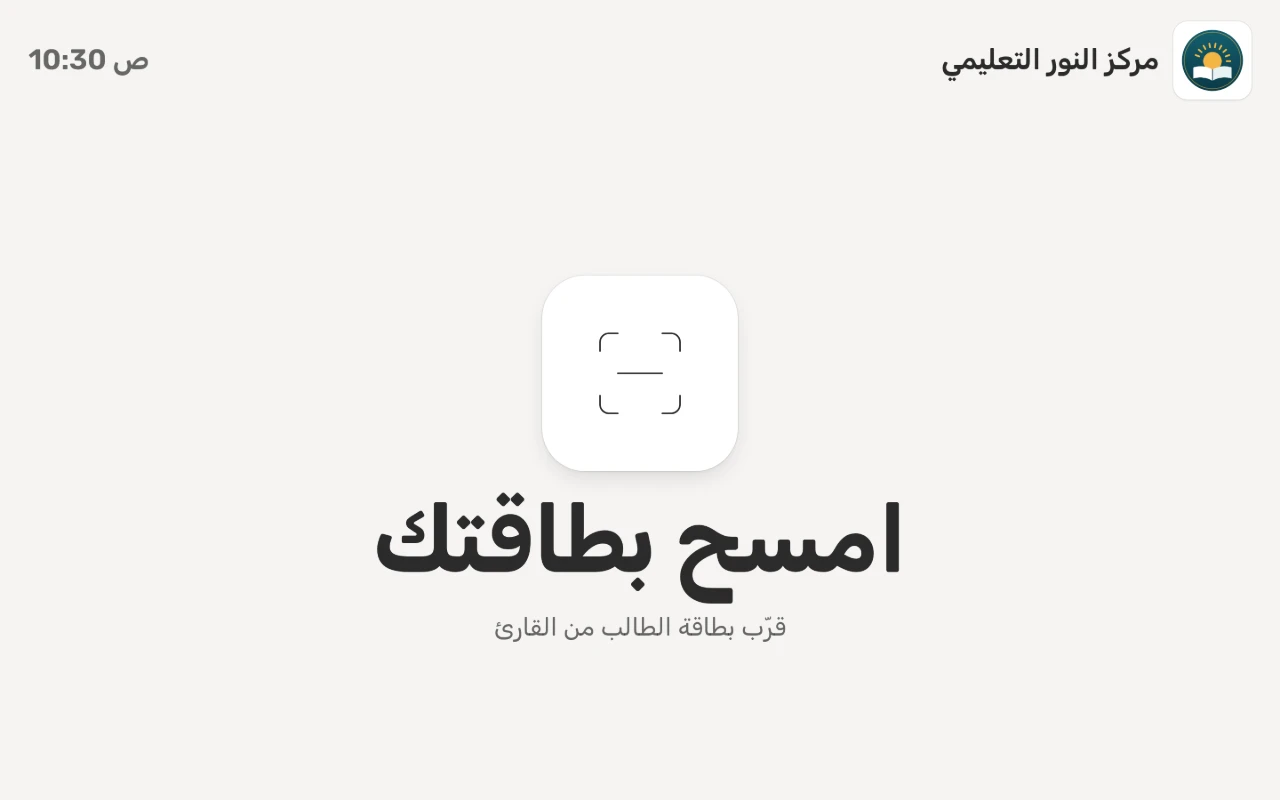 جهاز الحضور الذاتي عند مدخل المركز ينتظر: «امسح بطاقتك» تحت شعار المركز واسمه